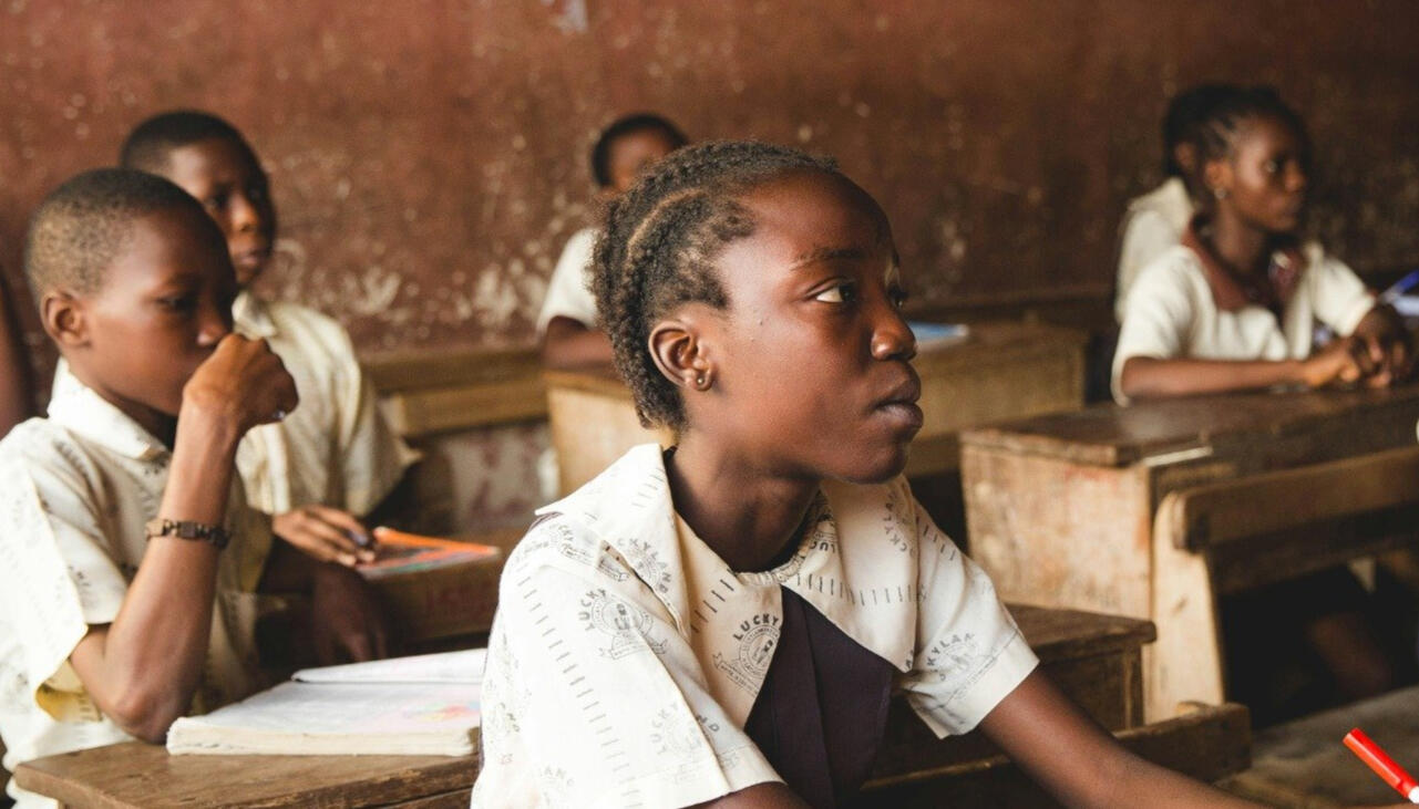 Écoliers camerounais en uniforme attentifs en classe dans une école rurale sans manuels scolaires